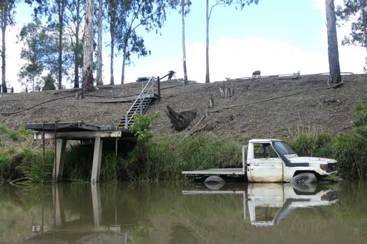 Old 4WD stripped down and placed into the river for a dock