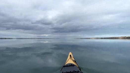 flat mirror waters with dark storm clouds