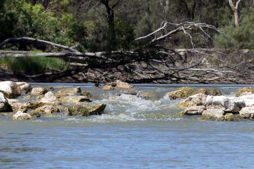 Flowing river over rock weir