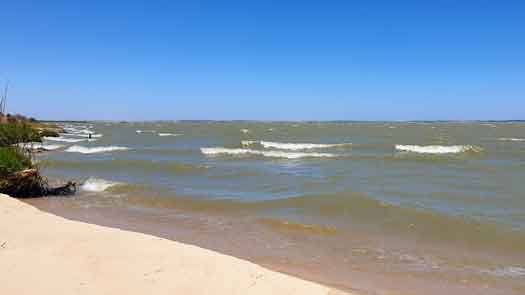 Looking along the shoreline of a lake with waves