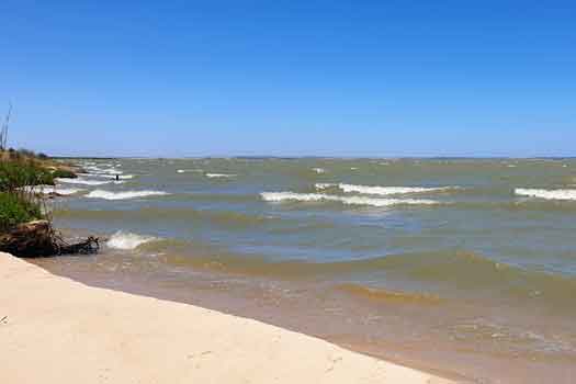 Looking along the shoreline of a lake with waves